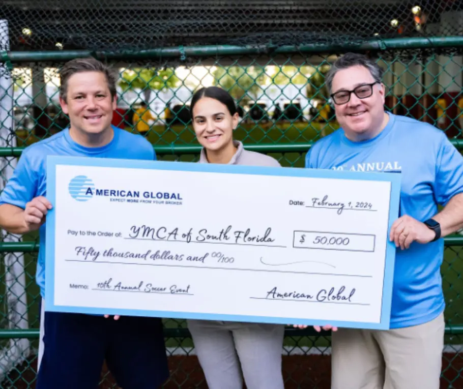 Three people holding a large check in front of them.