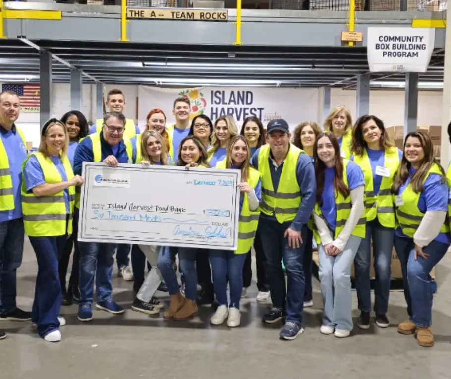 A group of people in yellow vests holding up a giant check.