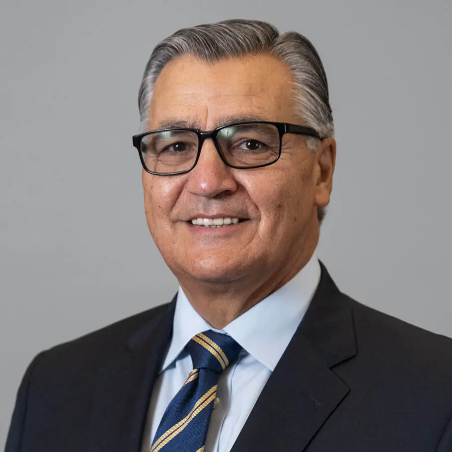 A man in suit and tie smiling for the camera.