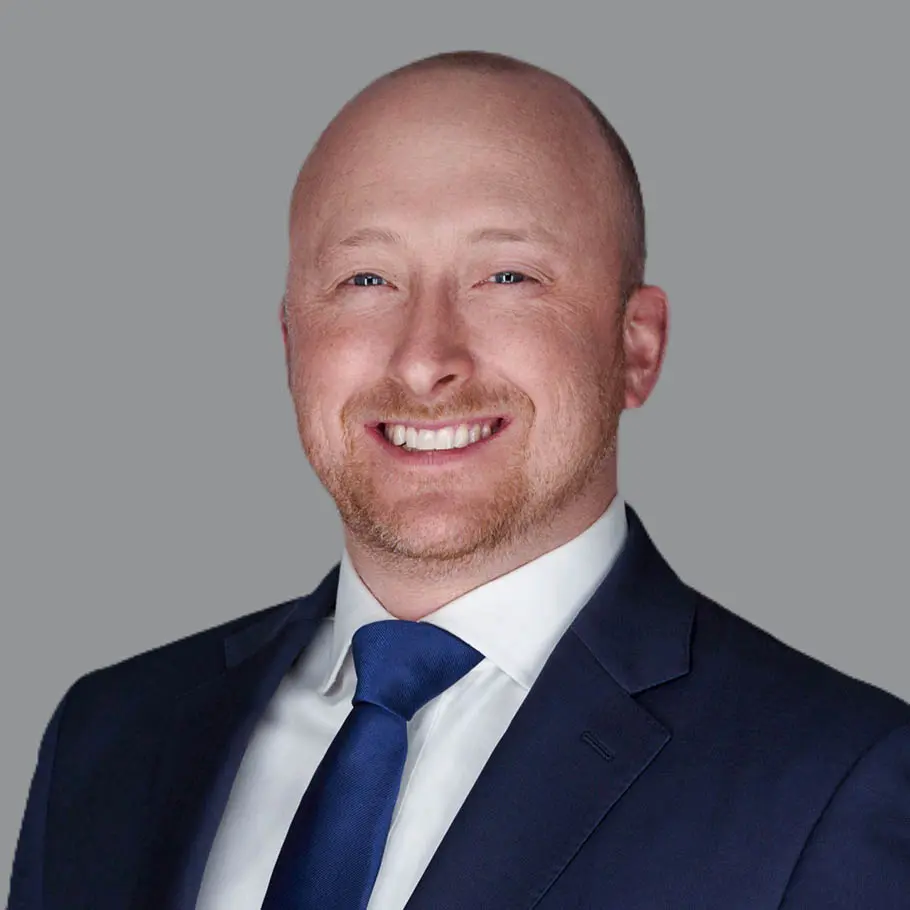 A man in a suit and tie smiling for the camera.