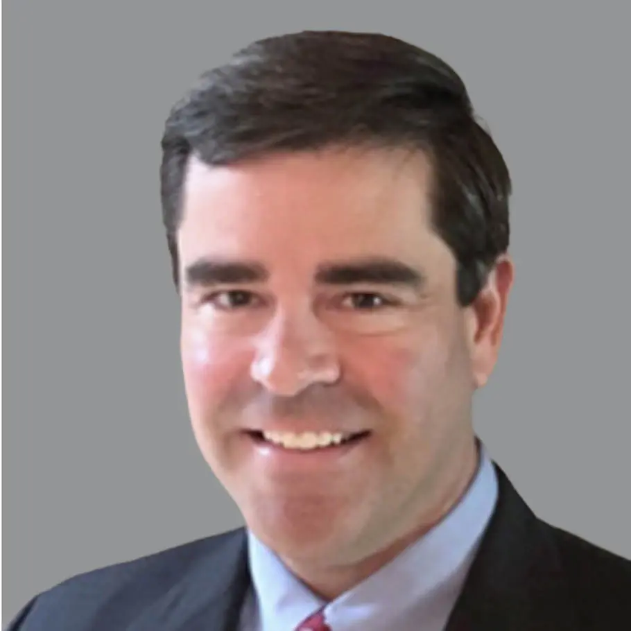 A man in suit and tie smiling for the camera.