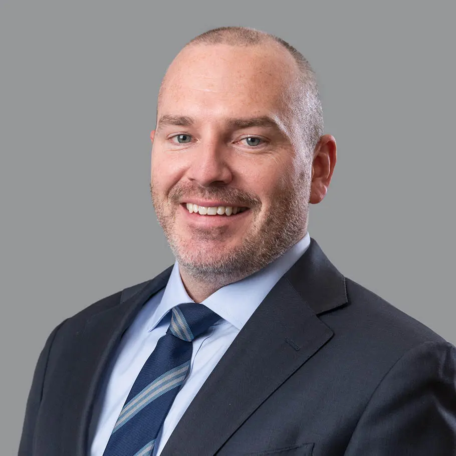 A man in suit and tie smiling for the camera.