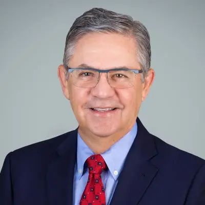 A man in a suit and tie smiling for the camera.