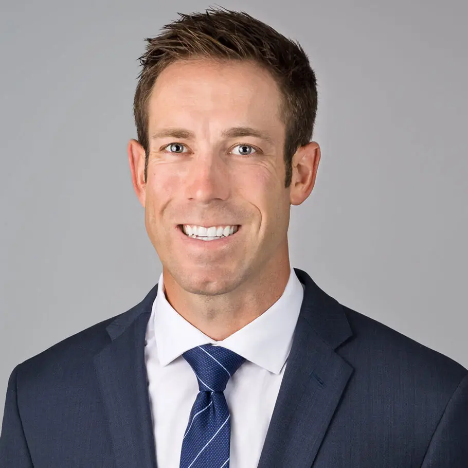 A man in suit and tie smiling for the camera.