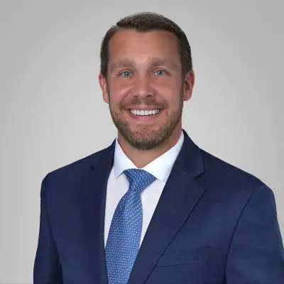 A man in a suit and tie smiling for the camera.