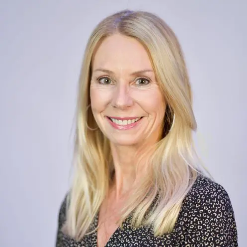 A woman with long blonde hair wearing a black shirt.