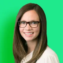 A woman with glasses is smiling for the camera.