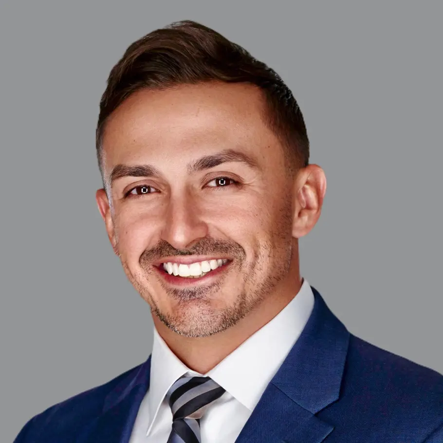 A man in a suit and tie smiling for the camera.