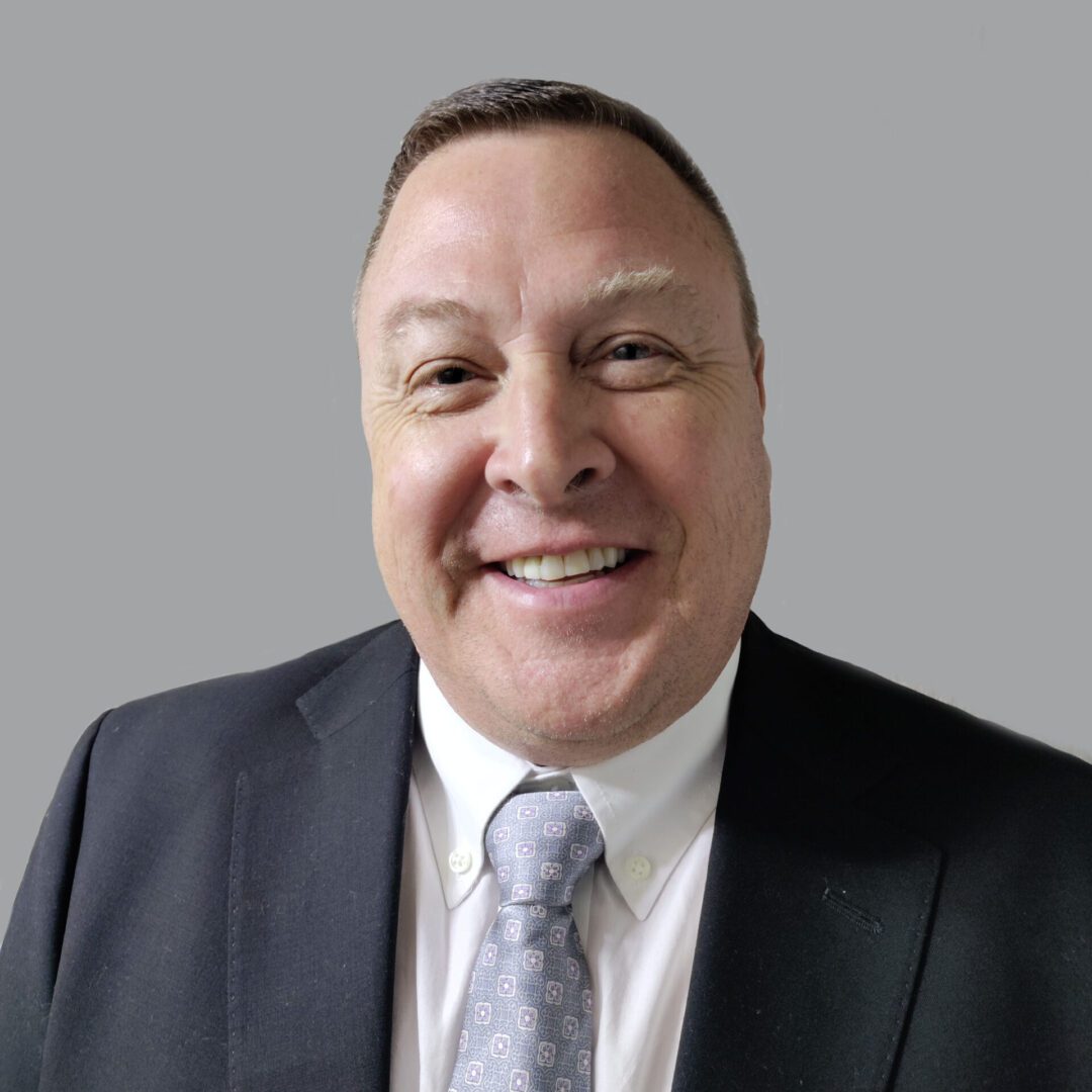 Smiling man in a suit and tie.