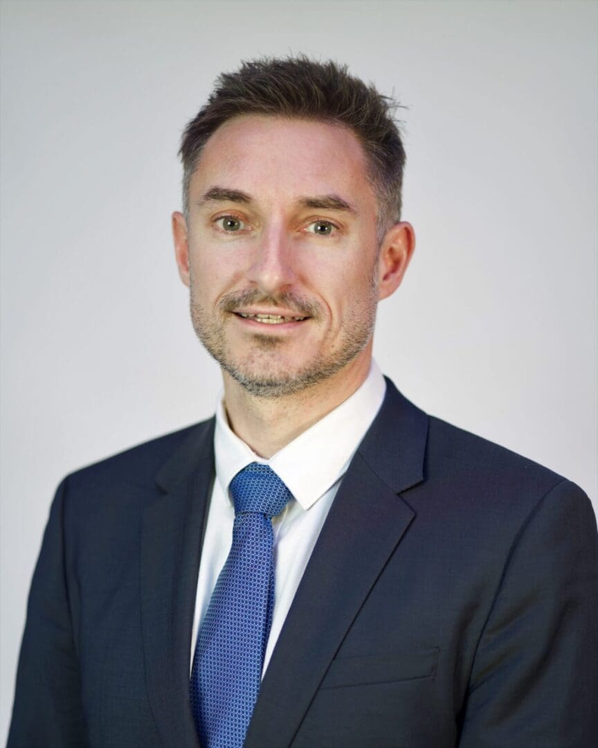 Man in a suit with a blue tie.