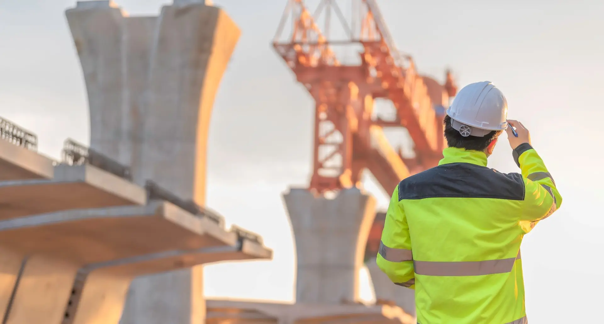 Construction worker inspecting bridge under construction.