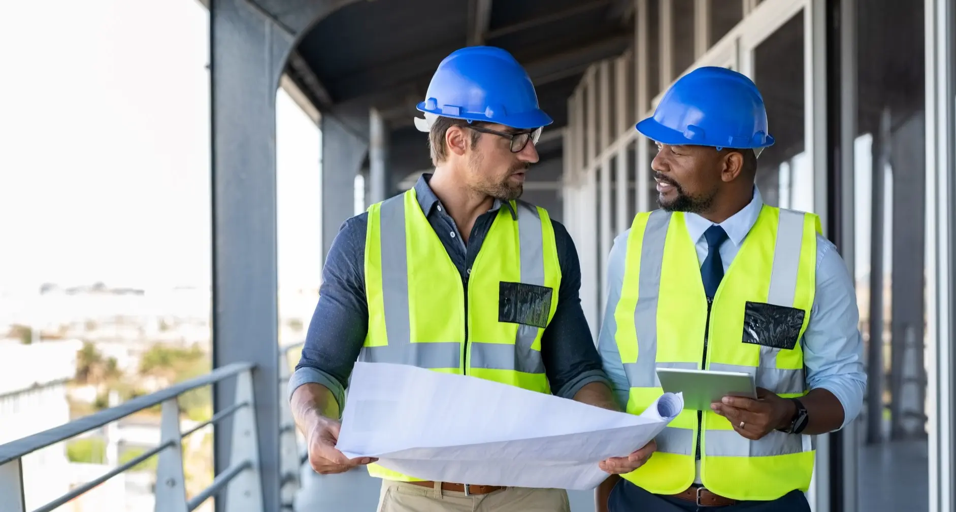 Two construction workers review blueprints.