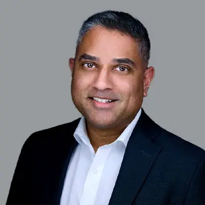 Smiling man in a suit and white shirt.