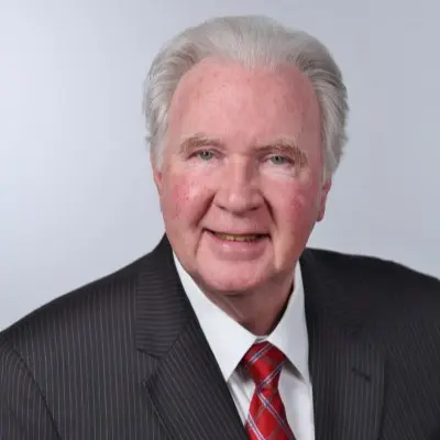 Smiling man in a suit and red tie.